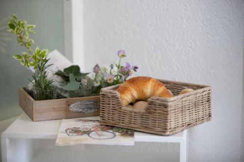 a cat sleeping in a basket on a table at Studio Living... in Langnau