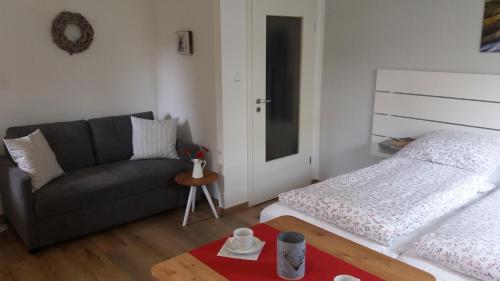 una sala de estar con un sofá y una cama en Appartement An der Radau, en Bad Harzburg