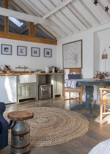 a living room with a table and a kitchen at Crafts Hill Barn in Cambridge
