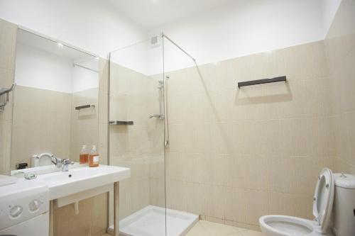 a bathroom with a shower and a sink and a toilet at Seaside Duplex Stone Villa in Qeparo