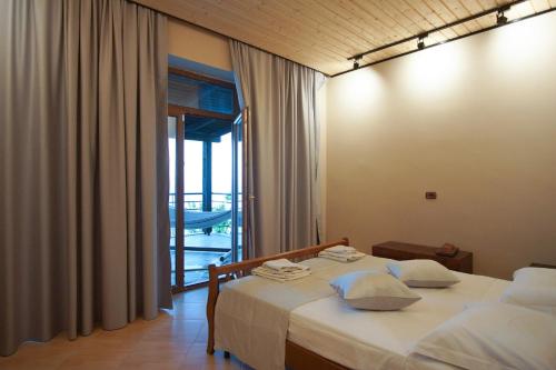 a hotel room with a bed and a balcony at Seaside Duplex Stone Villa in Qeparo