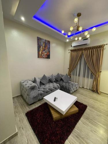 a living room with a couch and a table at God's Touch Apartments Signature in Lagos