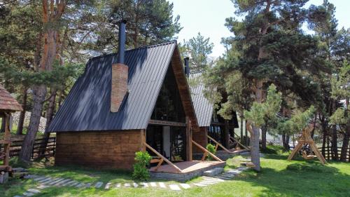 eine kleine Hütte mit einem Metalldach auf dem Rasen in der Unterkunft Elia Loft in Kazbegi