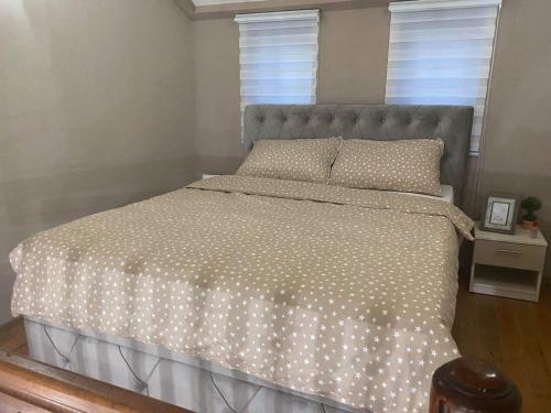 - une chambre avec un grand lit et une couette blanche dans l'établissement Apartman Royal, à Gornji Milanovac