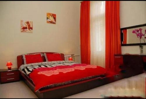 a bedroom with a red bed and a red curtain at Amazing view of St. Michael’s square in Kyiv