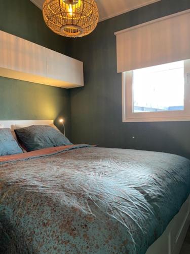 a bedroom with a large bed and a window at Wad Mooi in Tzummarum