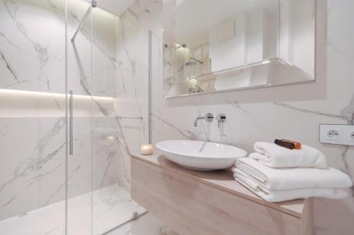 a white bathroom with a sink and a mirror at Balticus Sea View in Międzyzdroje