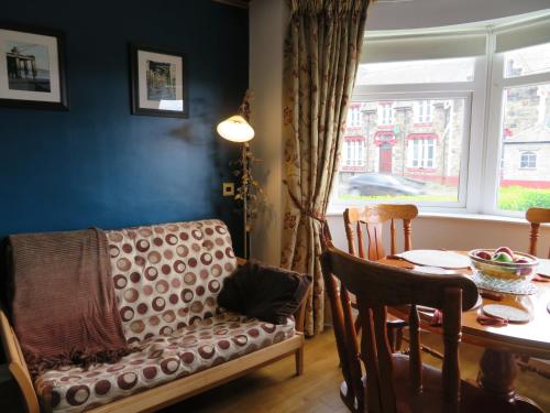 a living room with a couch and a table and a window at Lissadell Holiday Apartment in Buncrana