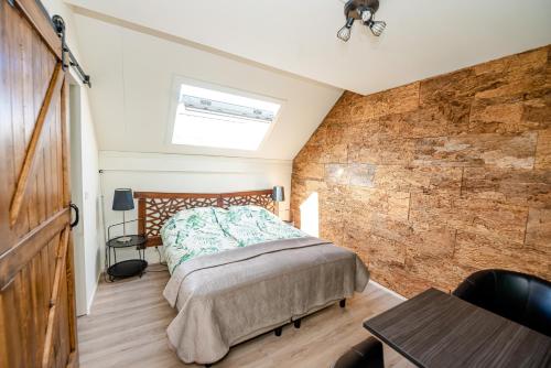 a bedroom with a bed and a brick wall at Bed & Breakfast Ohé en Laak in Ohé en Laak
