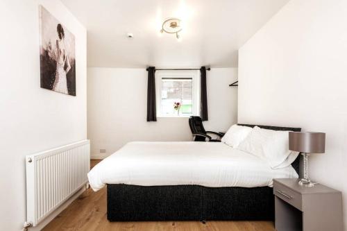 een slaapkamer met een groot bed en een raam bij Liverpool City Centre - Fabulous 3 En-suite Bedrooms - Sleeps 10 People in Liverpool