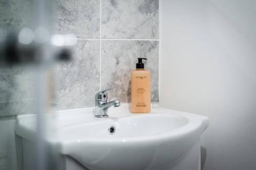 a bottle of soap sitting on a bathroom sink at Liverpool City Centre - Fabulous 3 En-suite Bedrooms - Sleeps 10 People in Liverpool