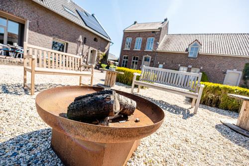 a fire pit in a yard with two benches at Bed & Breakfast Ohé en Laak in Ohé en Laak