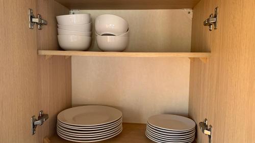two plates and bowls on a shelf in a kitchen at Cozy Private Static Caravan at Llyons Robin Hood - Silver Birch Way 11 in Rhyl