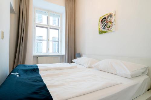 a white bed in a room with a window at Vienna Residence, Volkstheater - Parliament in Vienna
