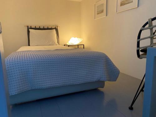 a bedroom with a bed with a blue and white blanket at Vourkari Village in Vourkarion