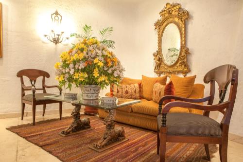 uma sala de estar com um sofá e uma mesa com flores em Antara Hotel & Suites - Miraflores em Lima