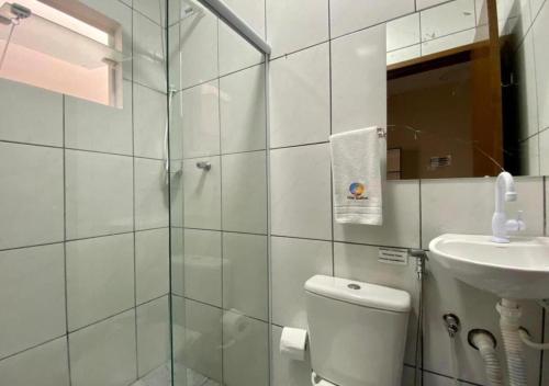 a bathroom with a shower and a toilet and a sink at Pousada Mar Suites in Ubatuba