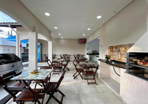 a restaurant with tables and chairs and a counter at Mar Suites Praia Grande in Ubatuba