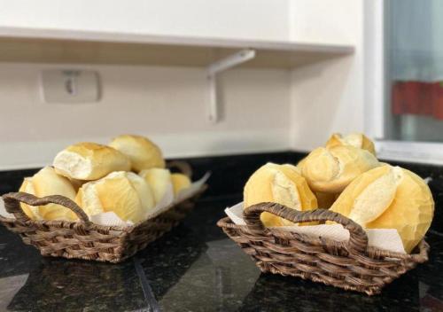 two baskets filled with bread sitting on a counter at Mar Suites Praia Grande in Ubatuba