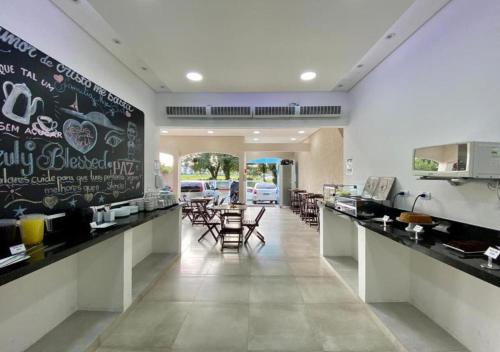 a restaurant with a chalkboard on the wall and tables and chairs at Mar Suites Praia Grande in Ubatuba