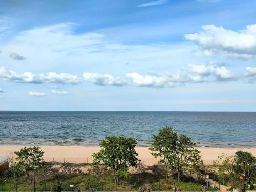 widok na plażę z drzewami i ocean w obiekcie Lido Dom Przy Plaży w Gdańsku