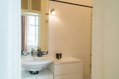 baño blanco con lavabo y ventana en Vienna Residence, Am Heumarkt - Stadtpark, en Viena