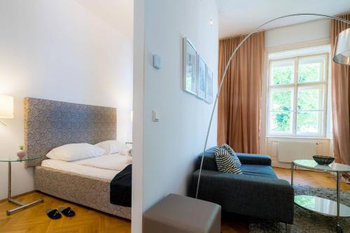 een slaapkamer met een bed en een stoel in een kamer bij Vienna Residence, Am Heumarkt - Stadtpark in Wenen