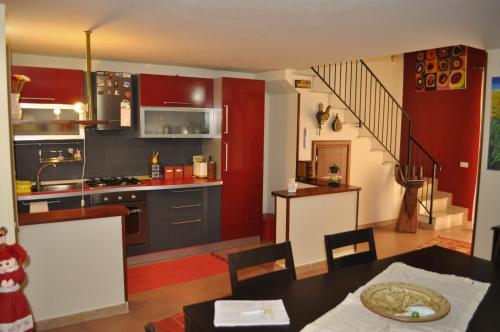 eine Küche mit roten und grauen Schränken und einem Tisch in der Unterkunft Kalza House in Palermo