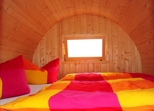 - une chambre avec un lit dans une pièce en bois dans l'établissement Mini Hotel Übernachten Im Gurkenfass, à Lübbenau