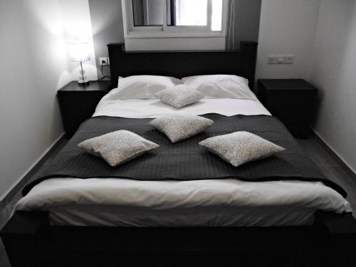 a large bed with four pillows on it at City Apartments in Eilat