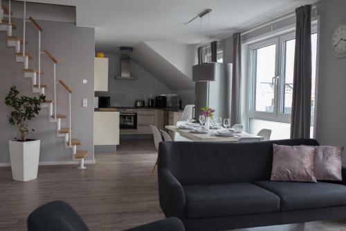 een woonkamer met een bank en een eetkamer bij moderne Neubau-Wohnung mit Kamin und 35qm Dachterrasse in Trossingen