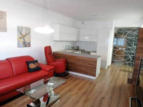 a living room with a red couch and a kitchen at Foreta in Bratislava