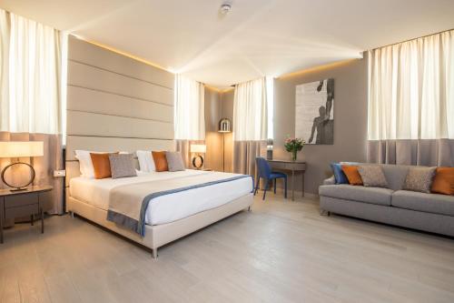 Orazio Palace Hotel في روما: غرفه فندقيه بسرير واريكه