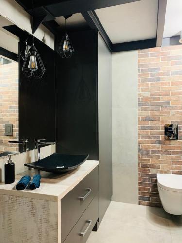 a bathroom with a sink and a toilet at Loft De Girarda in Żyrardów