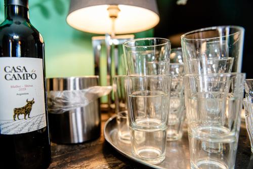 a table with glasses and a bottle of wine at Bed & Breakfast Ohé en Laak in Ohé en Laak