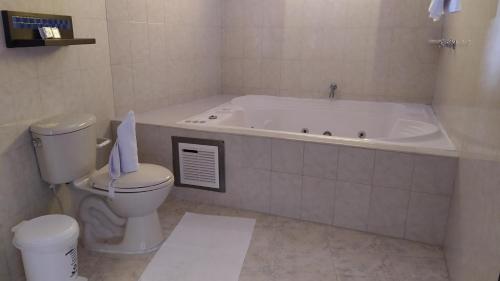 a bathroom with a bath tub and a toilet at Hotel Las Rocas Resort Villanueva in Villanueva