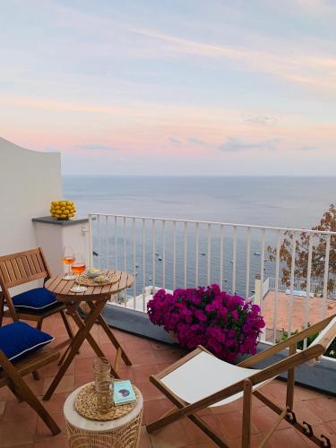 a balcony with a table and chairs and the ocean at Villa Fortuna in Positano