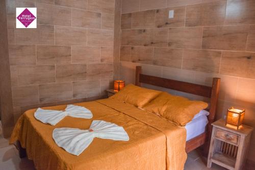 a bedroom with a bed with towels on it at Hotel Ferrugem Eco Village in Garopaba