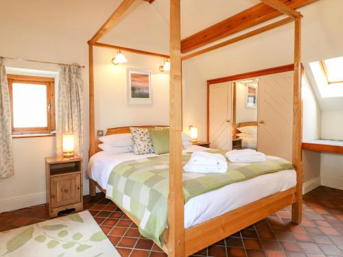 een slaapkamer met een hemelbed in een kamer bij Slade Tops in Ashbourne