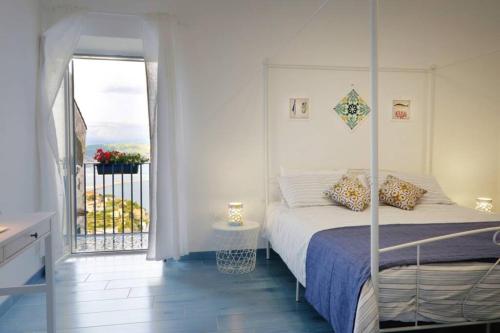 a bedroom with a bed and a balcony at Il Nido di Raito in Vietri sul Mare