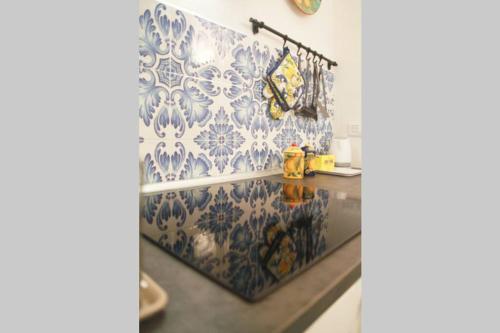 a kitchen with blue and white tiles on the wall at Il Nido di Raito in Vietri sul Mare