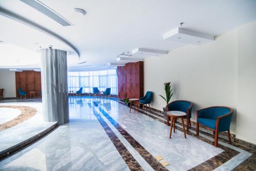 a swimming pool in a room with blue chairs at Lamar Azur Hotel in Dumyāţ al Jadīdah