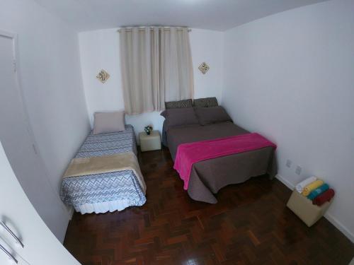 サルバドールにあるAp Ondinaのベッド2台と窓が備わる小さな客室です。