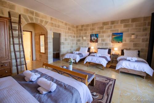 a bedroom with four beds in a room at Bebbuxa Holiday Home in Għarb
