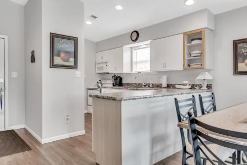ブランソンにあるWest Rockford Condo 140の白いキャビネットとテーブル付きのキッチン