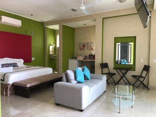a hotel room with two beds and a couch at Casa Mia in Puerto Escondido