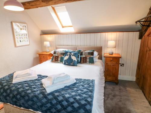 阿什伯恩的住宿－Slade Cottage，一间卧室配有带毛巾的床