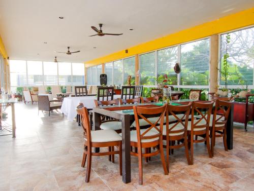 a dining room with a table and chairs and windows at Casa Bakab By Rotamundos in Chablekal