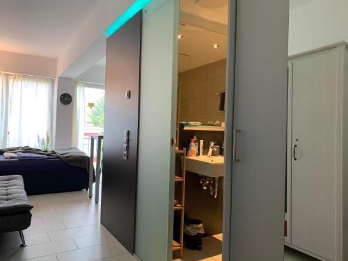 Habitación con una puerta que conduce a un dormitorio en Exklusive Wohlfühloase by Rabe - Parkplatz & free Netflix & Coffee-Bar en Karlsruhe