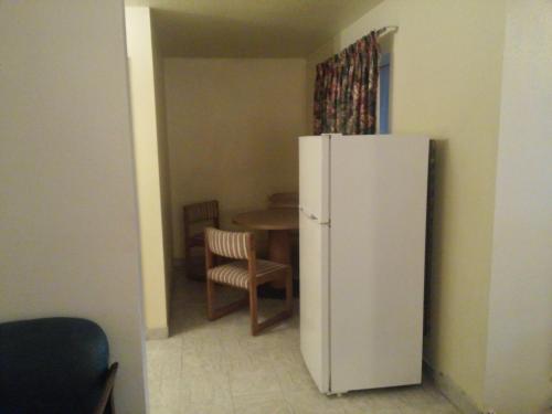 a kitchen with a white refrigerator and a table at Evergreen Inn in Covina